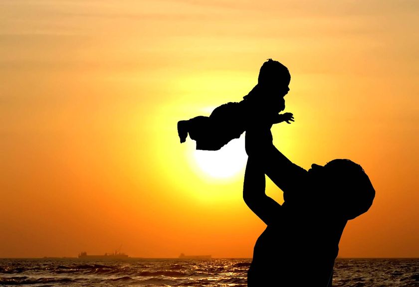 parent holding child in sunset as example of adoption guardianship